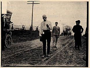 "The Pedestrian" at age 69, walking along a dirt road near Chicago where he arrived on Nov. 27th, 1907, after a walk of 1200 miles from Portland, Maine. DN-0052117, Chicago Daily News collection, courtesy of the Chicago Historical Society. 